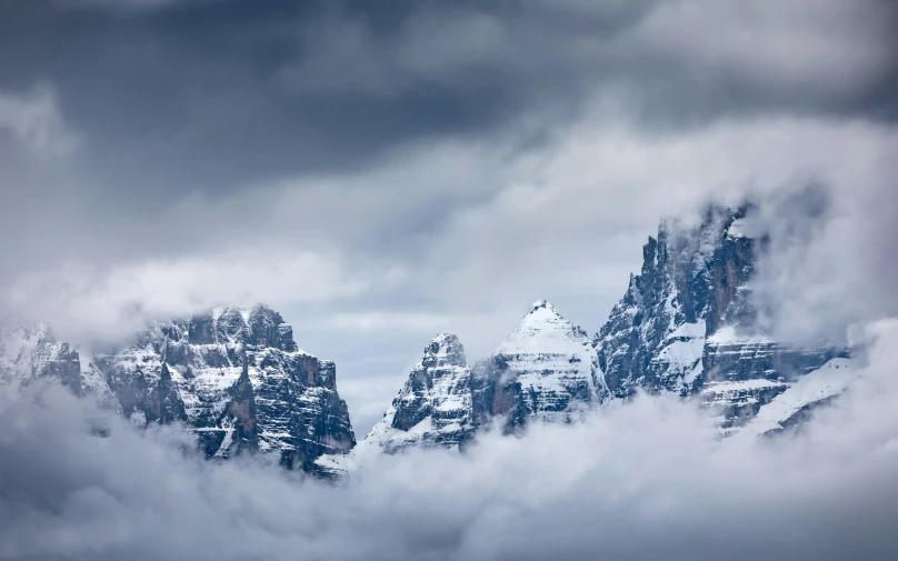 some mountain range with a couple of clouds coming out of it