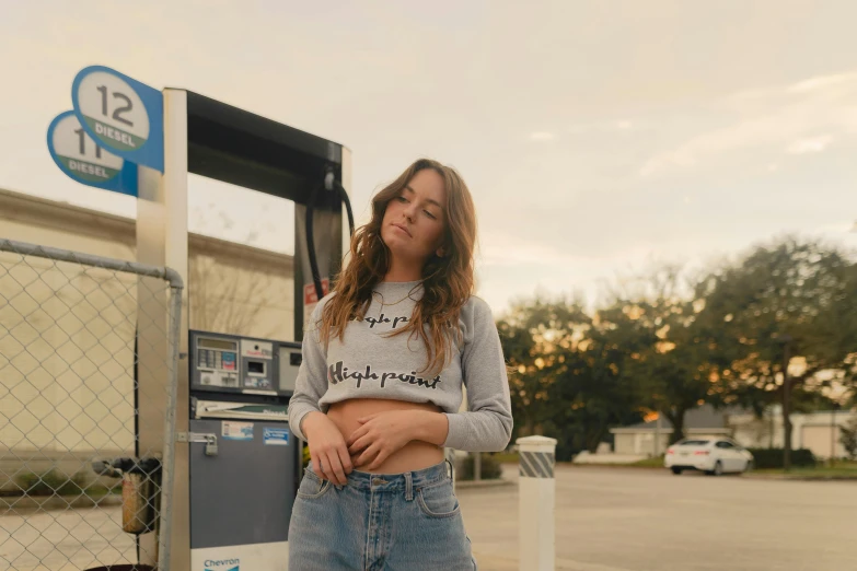 a woman leaning against a fuel pump