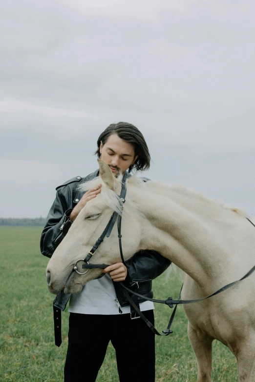 the young man is hugging his horse in the field