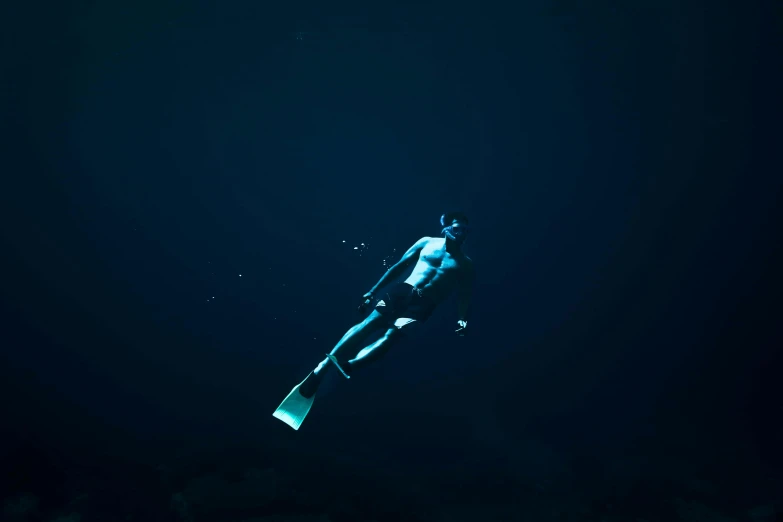 a person wearing a wet suit, swimming with a surfboard