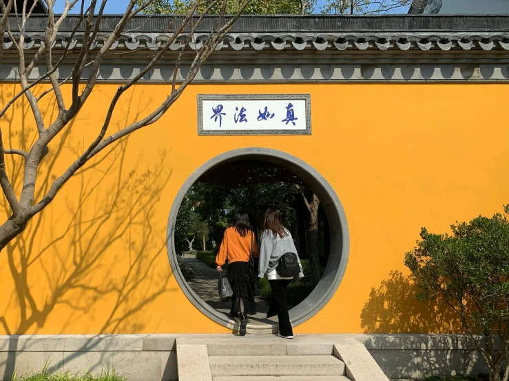 a couple of people walk around a circular entrance