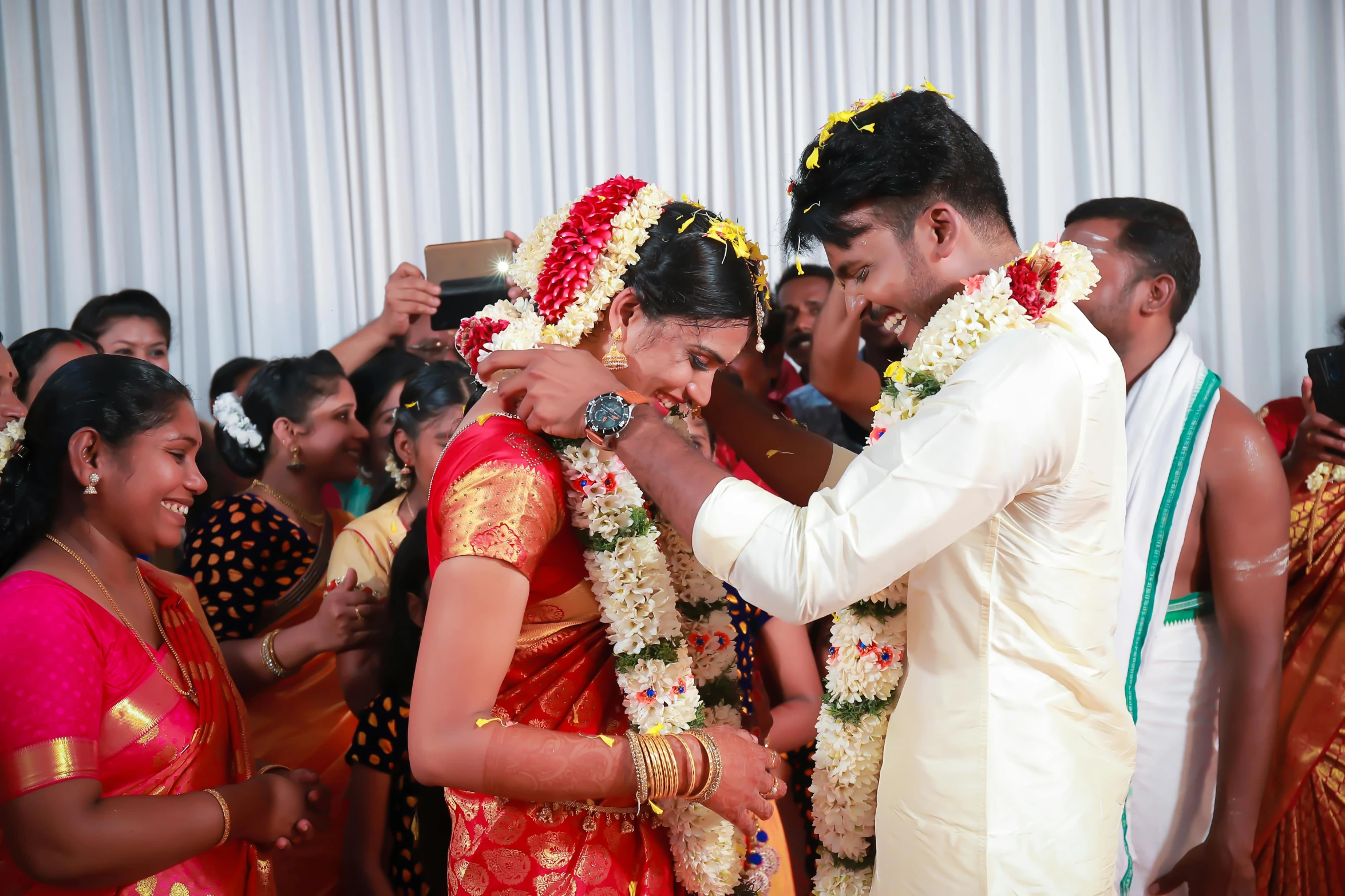 a woman and a man putting on garlands