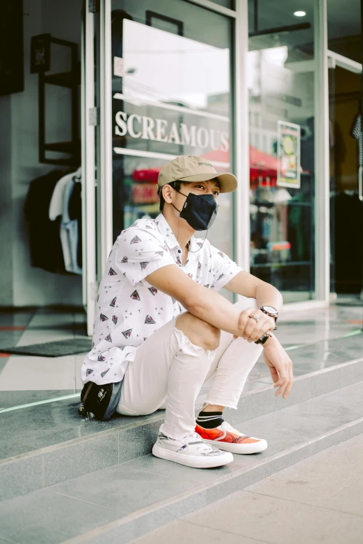 a person with a mask sitting on the ground near a building