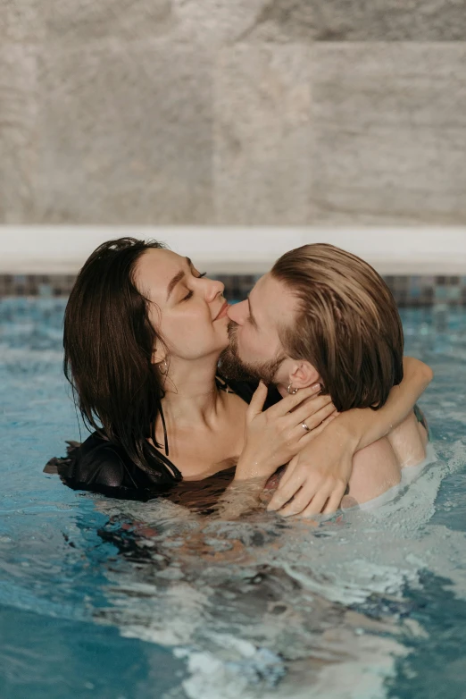 a couple kissing while swimming in a pool