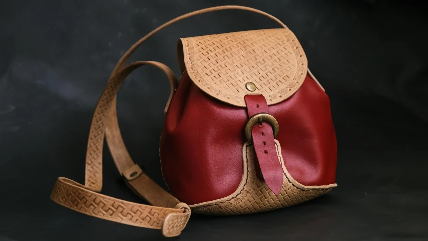 a small red handbag is sitting on the ground