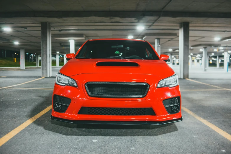 a red car is parked in a parking garage
