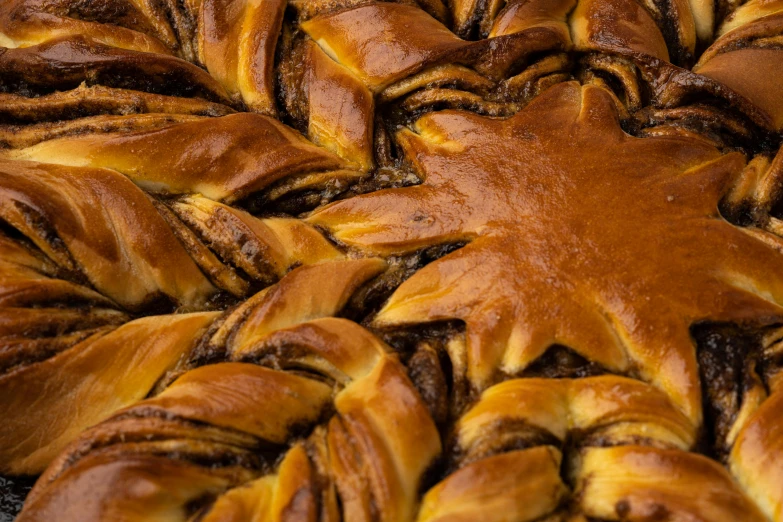 the large group of pastry are covered in brown icing