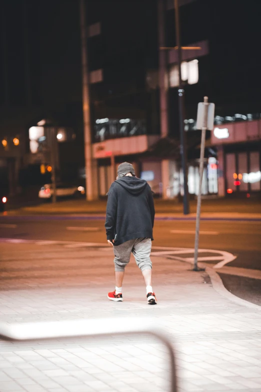 man in blue jacket skateboarding at night in urban setting