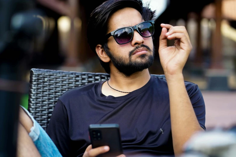 a man sitting in a chair with a phone