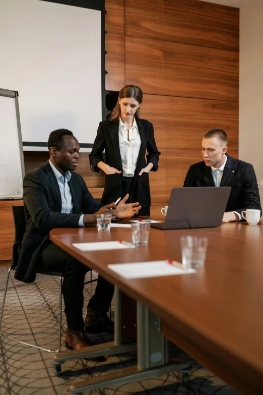 a woman holding a microphone, two other men and a laptop