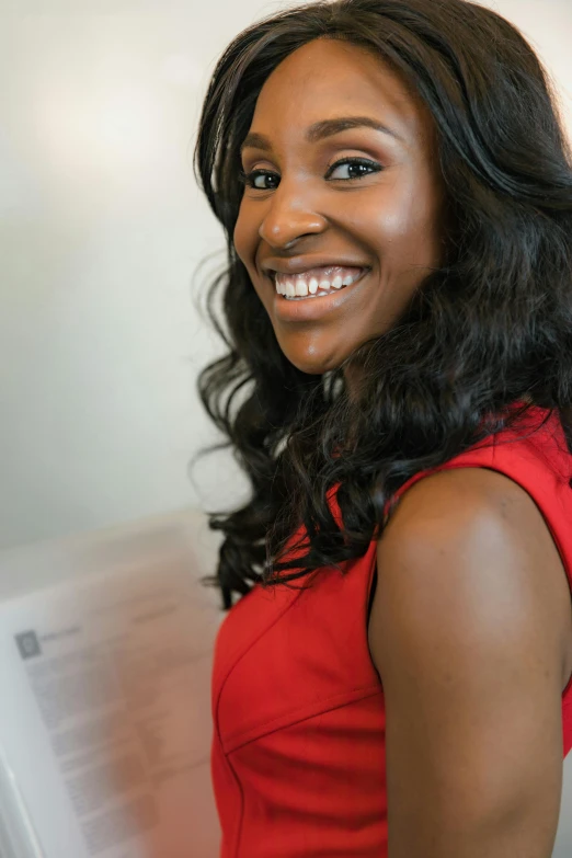 a smiling woman with long dark hair in a red dress