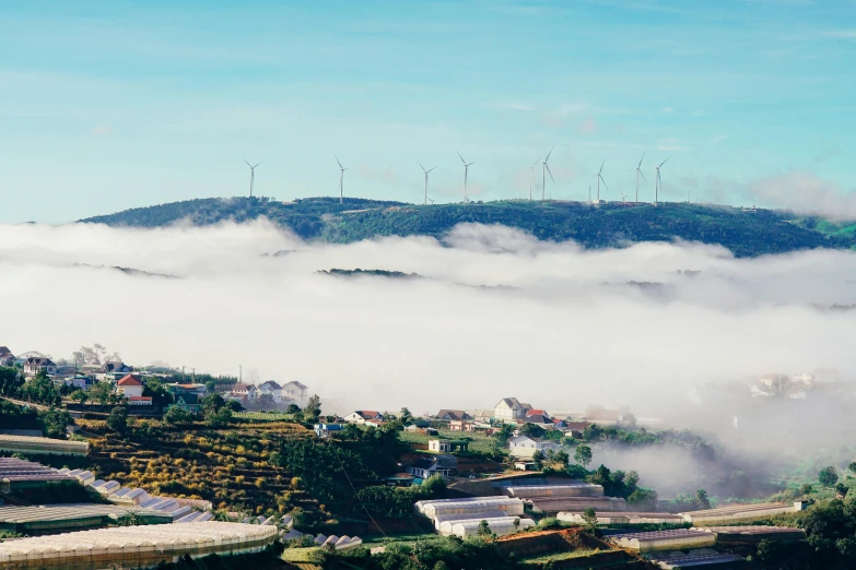 mountains, clouds, and houses on the hillside are pictured