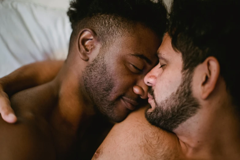two male friends laying in bed, emcing
