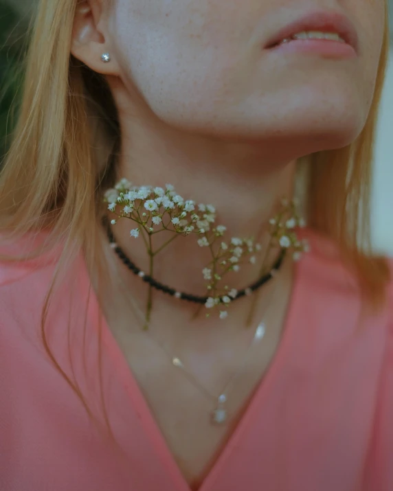 a close up of a woman with flowers in her neck