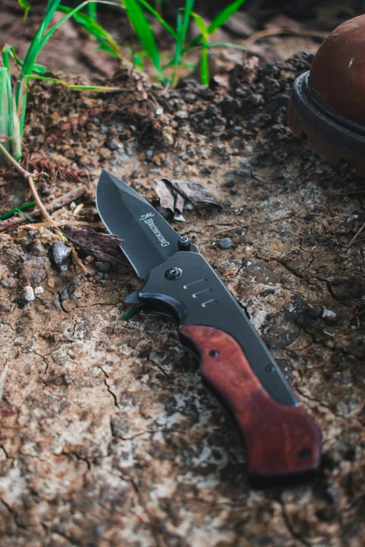 a knife laying on top of a rock on the ground