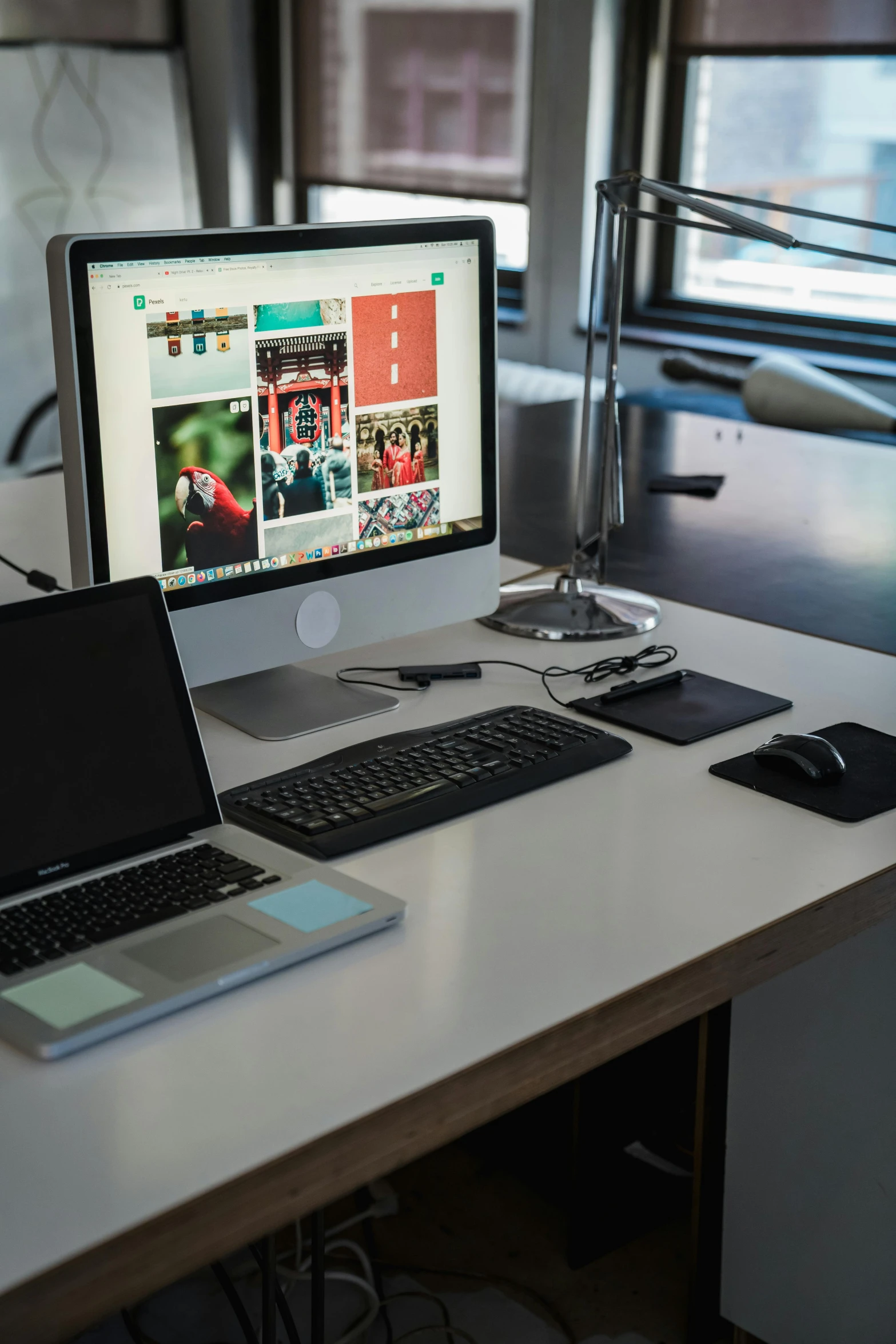 a desk with a monitor, keyboard and laptop on it