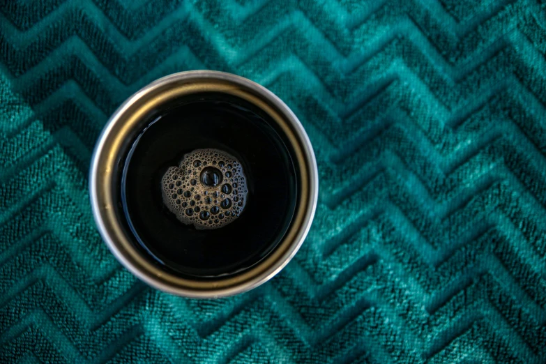 a tea cup is sitting on a green fabric