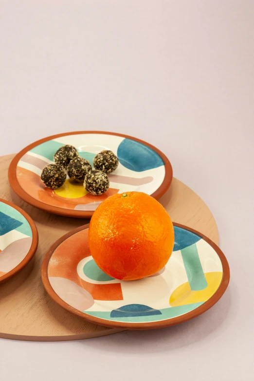 two plates on a table with oranges and berries