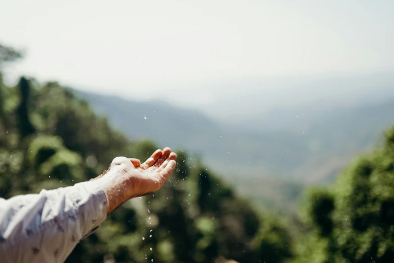 a man's arm and hand with water pouring from it