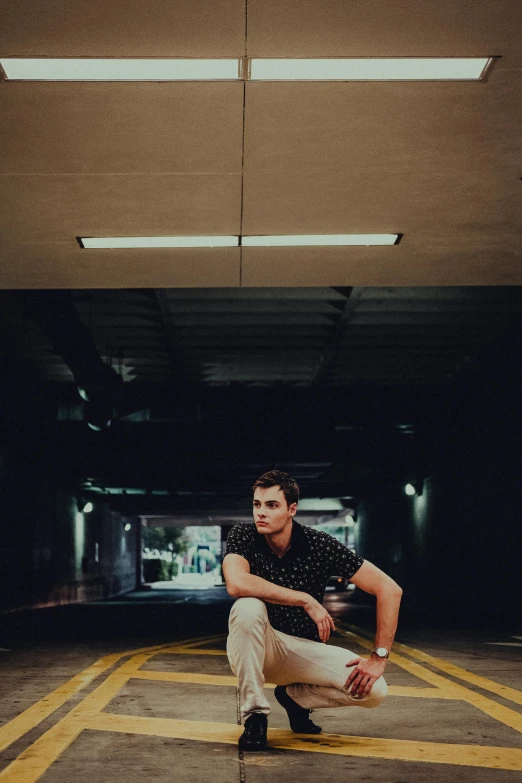 a man sitting on the floor in a parking garage