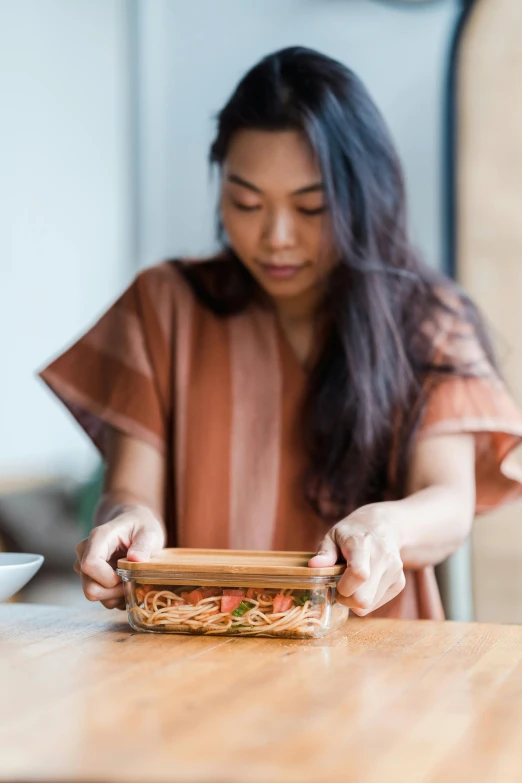 a woman is putting the finishing touches to an entree