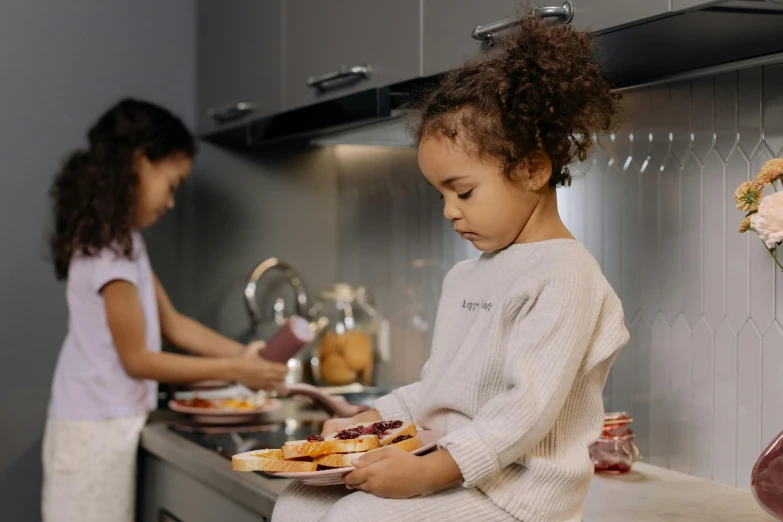 two girls who are preparing food in a kitchen