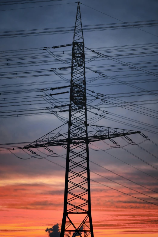 a tower with many electrical poles in the sunset