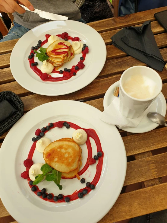 two desserts on white plates with fruit toppings