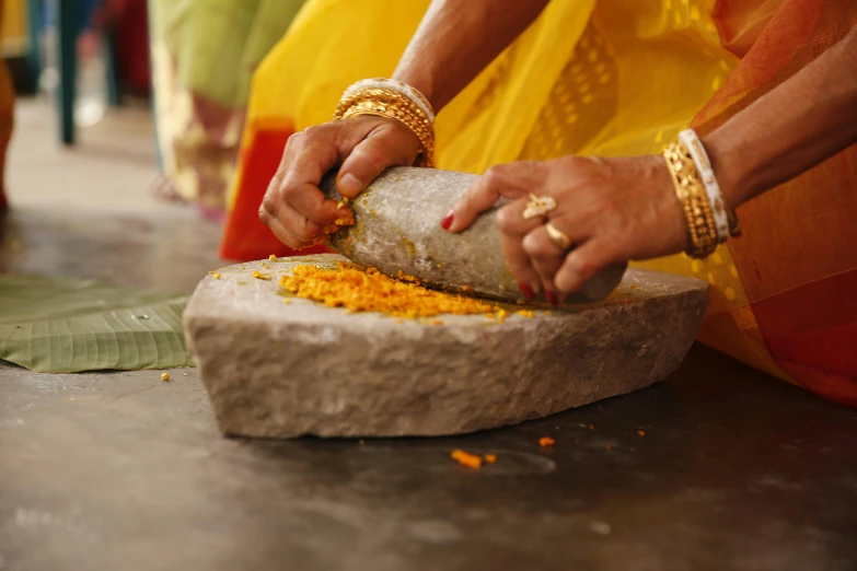 woman in yellow dress slicing up food with two fingers