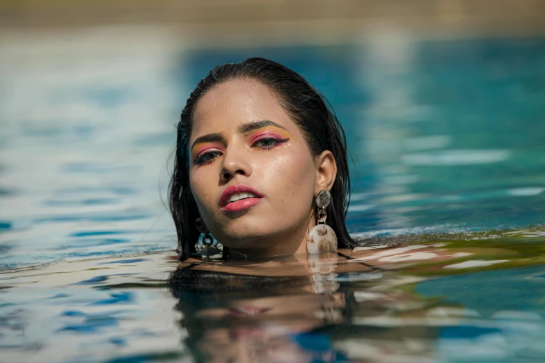 a woman in the water with colorful eyeshadow