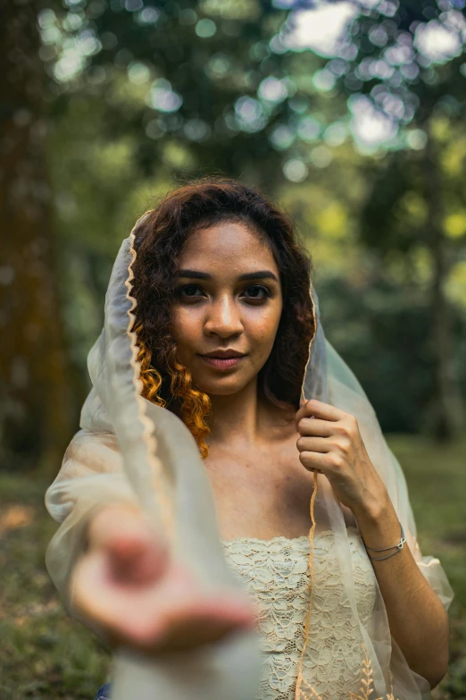 the woman is dressed up in a white dress and has an odd veil on