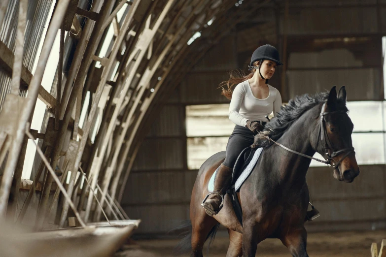 a young woman in riding gear riding on top of a horse