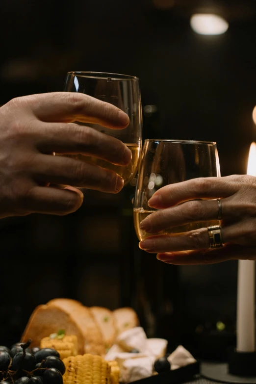 two hands with wedding rings toasting wine glass