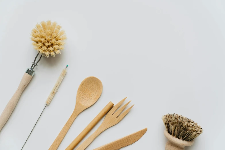 spoons, brushes and broom lying side by side