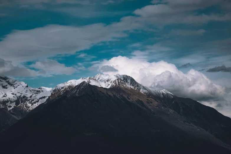 the top of a snowy mountain with snow capped peaks