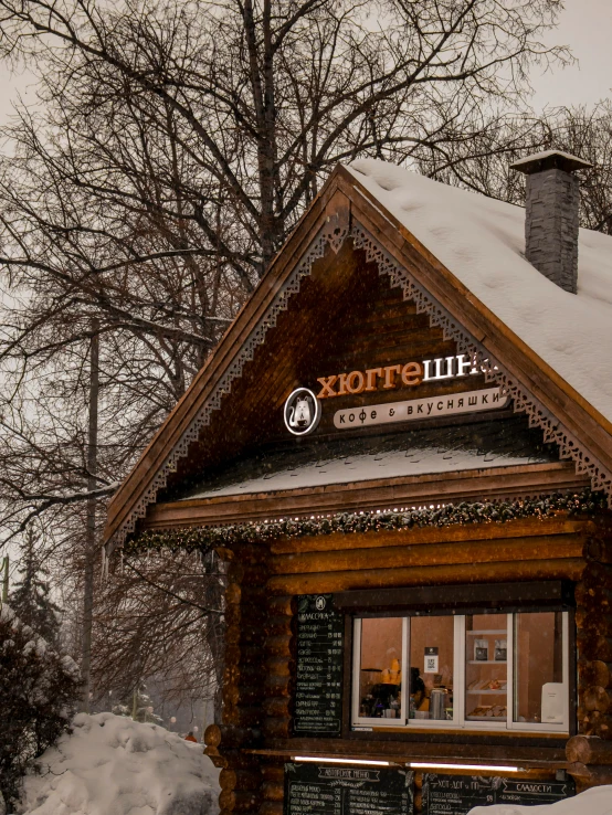 a building with wooden siding and snow on the roof