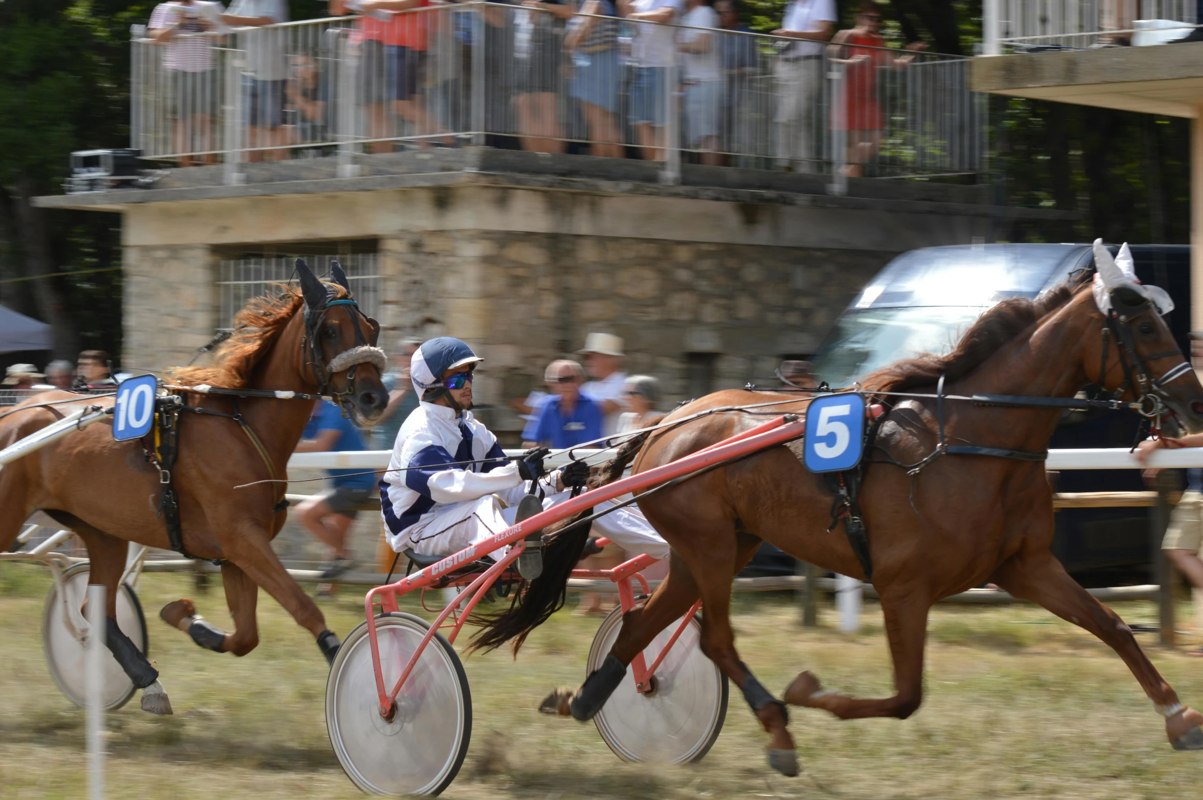 a couple of horses racing each other on a race track