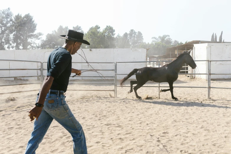 a man that is standing near a horse