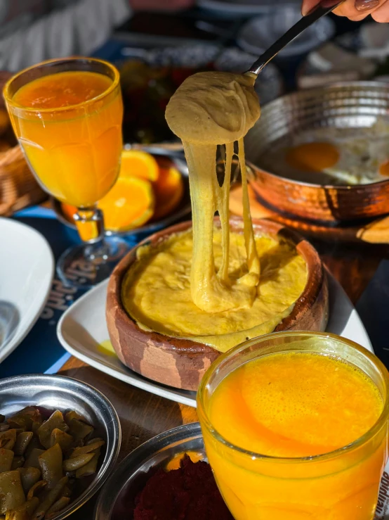 a plate full of food and two glasses filled with orange juice