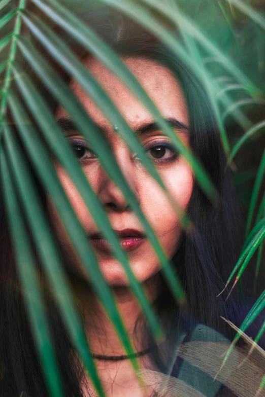 a woman in front of a green palm tree