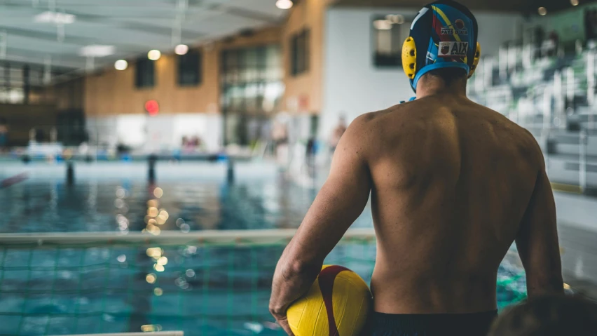 the back of a man with a blue and yellow helmet holding a red and yellow glove