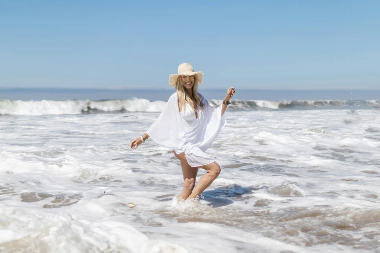 a young woman wading in the waves at the beach