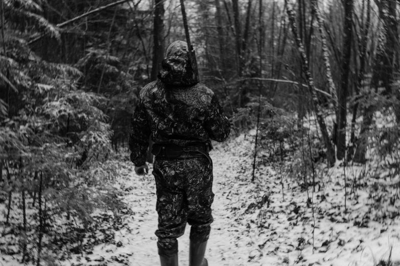 a man walking through the woods in the snow