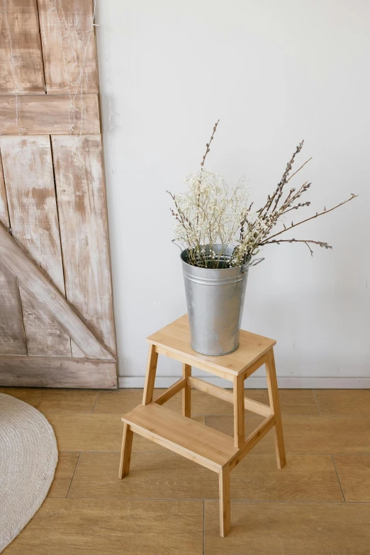 a wooden step stool has flowers in it