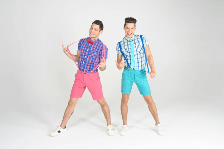 two men dressed in colorful clothes, one of which is holding soing