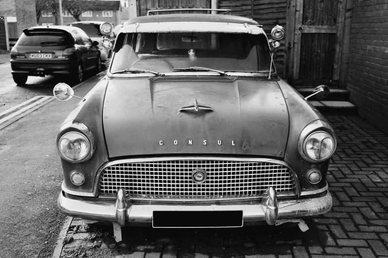 an old model car sitting in front of two older cars