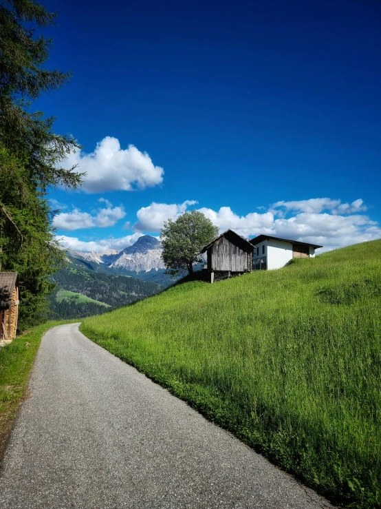 the wooden house is on a grassy hill