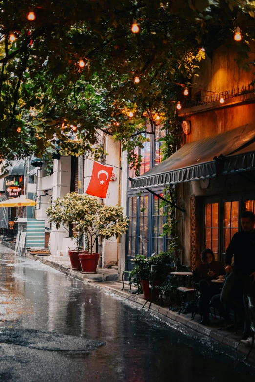 rain falls on a city street with several stores
