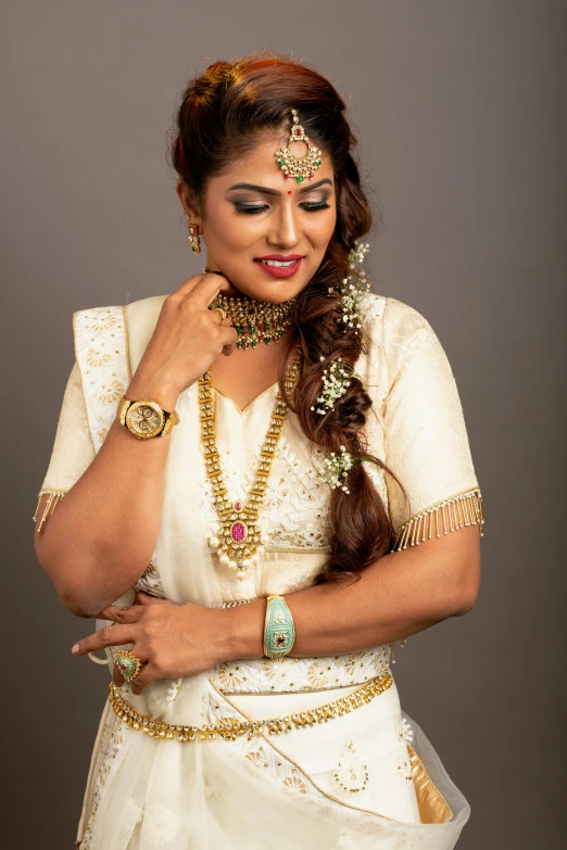 an indian woman wearing a wedding dress and holding her hands together