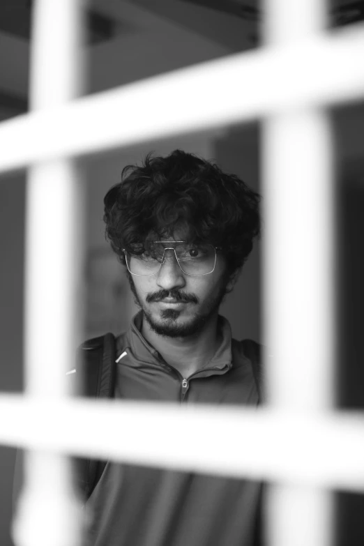 a man is posing in front of a window